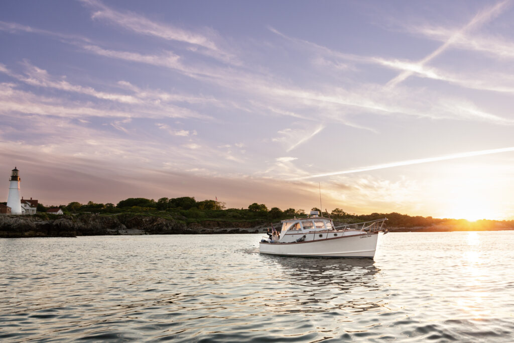 Boat at Sunset by Portland Head Light. Photo Credit: Sail Portland Maine