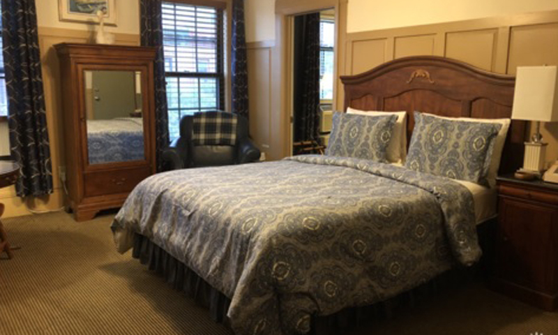 King Bedroom with Chair and Window View, Photo Courtesy of Percy Inn - listing