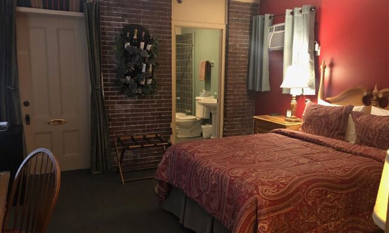 Red Bredroom with Brick Wall Decor, Photo Courtesy of Percy Inn - listing