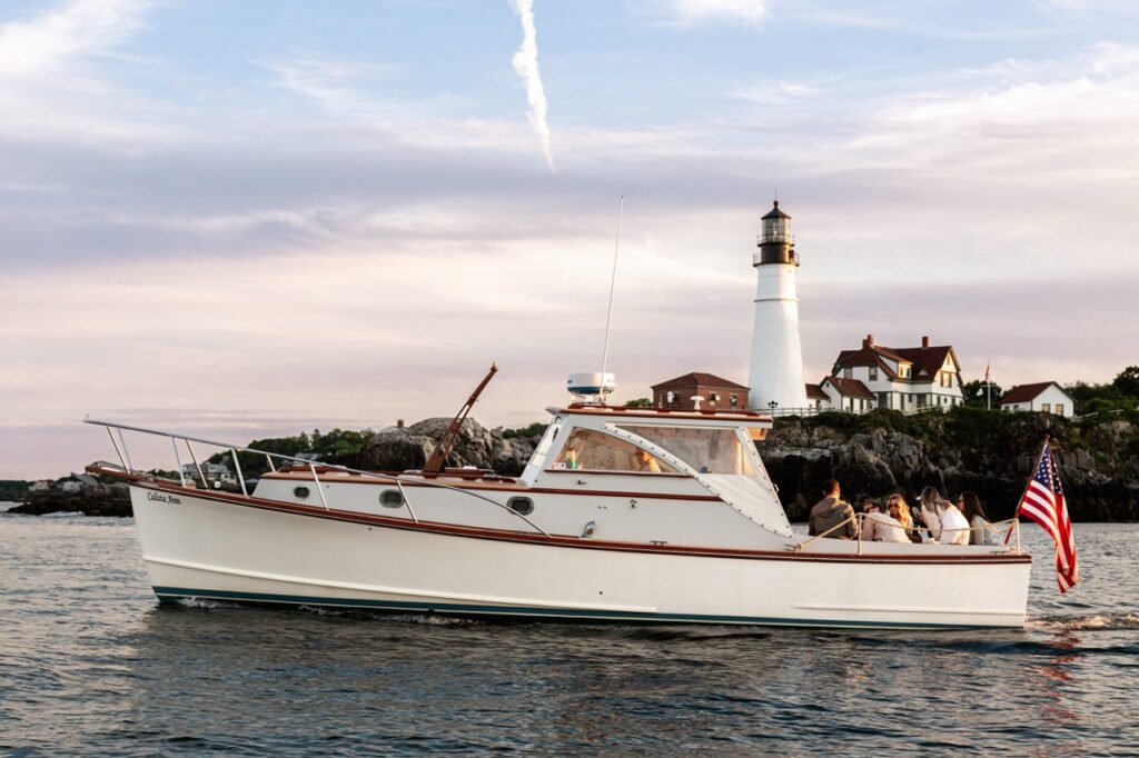 Boat Passing by Portland Head Light. Photo Credit: Sail Portland Maine
