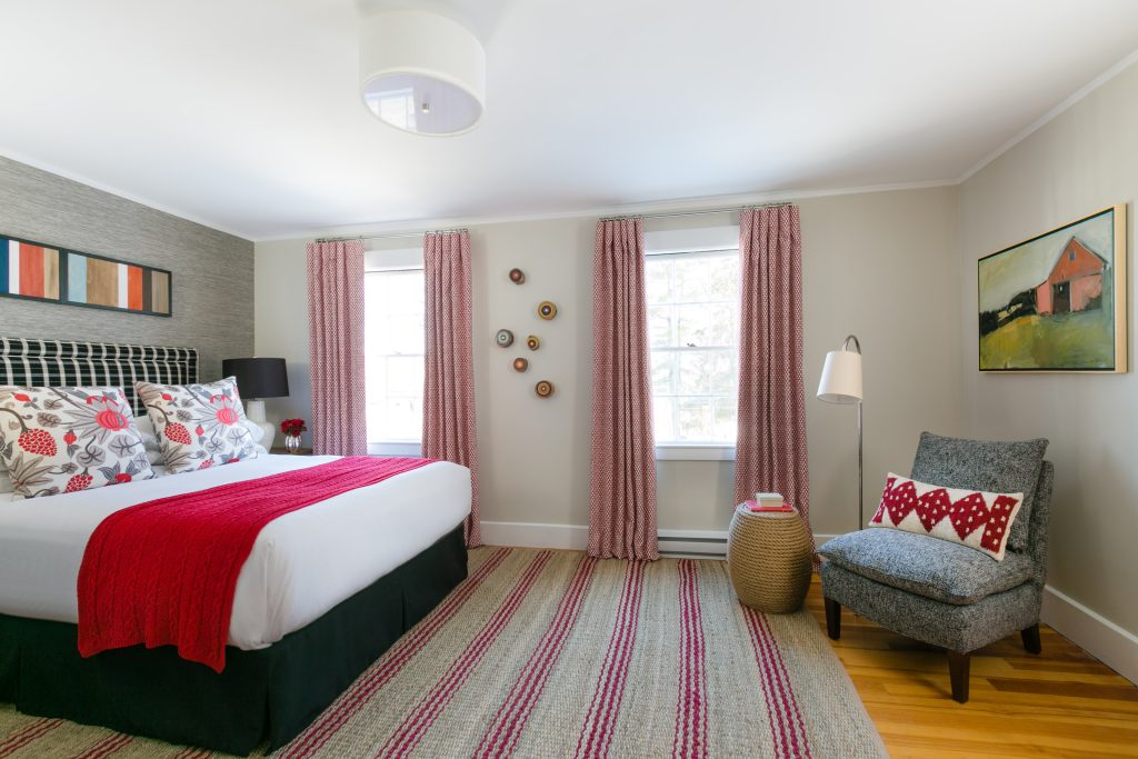 Guest room with a bed and seating area. Photo Credit: Rarebrick Photography