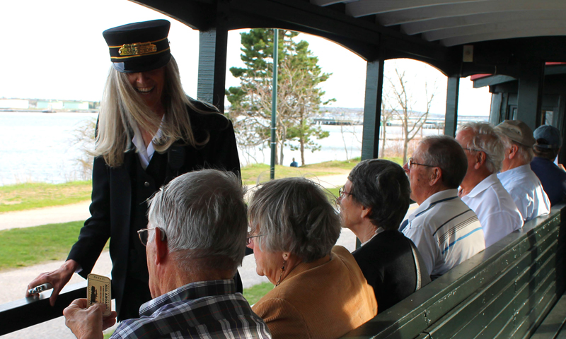 Conductor with Passengers. Photo Provided by Maine Narrow Gauge Railroad Company & Museum