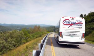 Bus on road with mountains in view. Photo Provided by Concord Coach Lines