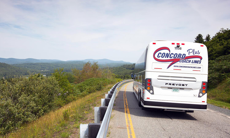 Bus on road with mountains in view. Photo Provided by Concord Coach Lines