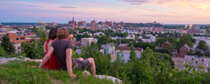 Couple sitting on hill over city, Photo Credit: Corey Templeton