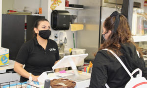 Customer and server in masks at Sal De La Tierra, Photo Courtesy Adam MacDonald / Portland Downtown
