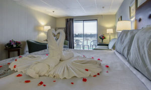 King Bed with Towel Swans and Rose Petals, Courtesy of Ocean Point Inn and Resort