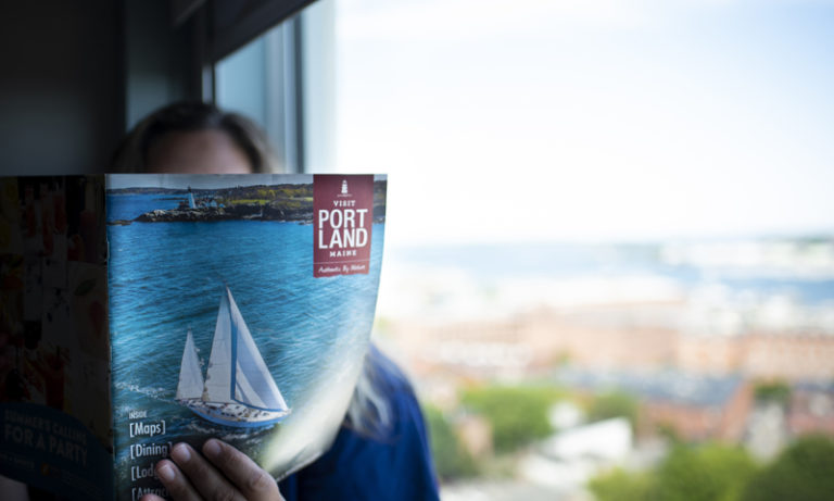 Holding Visitors Guide Photo Credit - Capshore Photography Holding Visitors Guide Photo Credit - Capshore Photography