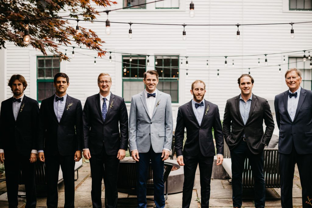 A groom and his groomsmen posing for a picture on the patio. Photo Credit: Lindsay Vann Photography