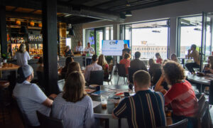 Media presentation to group of people at rooftop bar; Photo Credit: Lauren Peters at Visit Portland