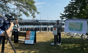 Person a giving press conference near boat marina and harbor; Photo Credit: Angie Helton