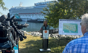 Woman giving press conference in front of a docked cruise ship; Photo Credit: Angie Helton