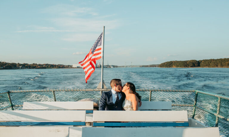 Wedding couple kissing and enjoying boat ride; Photo Credit: Kivalo