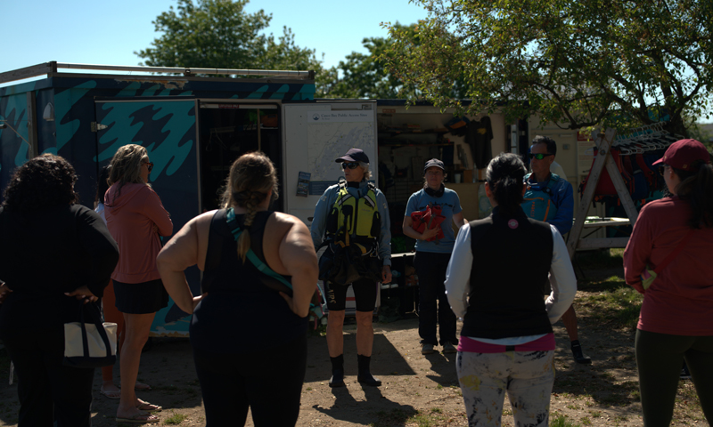 Group hearing paddle board instructions; Photo Credit: Digital Edge
