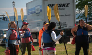 Group hearing paddle board instructions; Photo Credit: Digital Edge