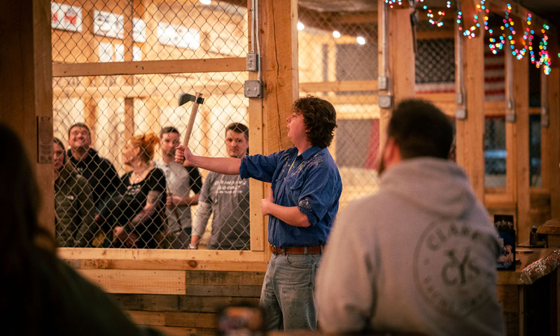 Person teaching others to throw axes; Photo Credit: Nate Davis