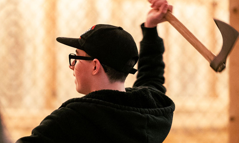 Person mid axe throw; Photo Credit: Nate Davis Person mid axe throw; Photo Credit: Nate Davis