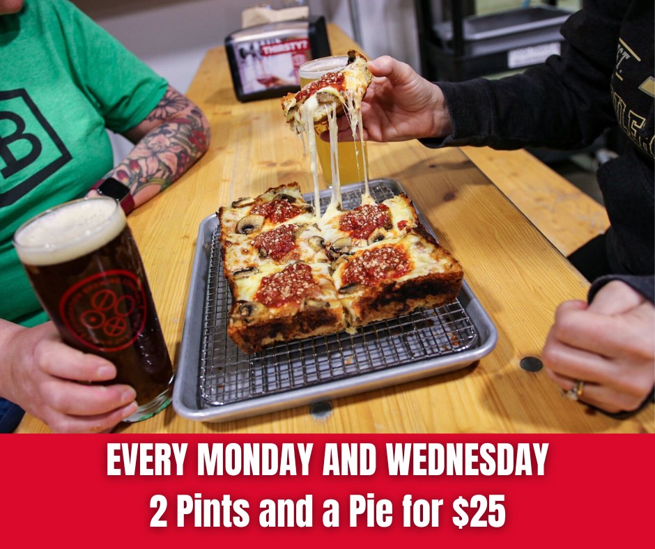 2 Pints and a Pie for $25 - Photo Credit: Foundation Brewing Company - Two people enjoying pizza and a beer.