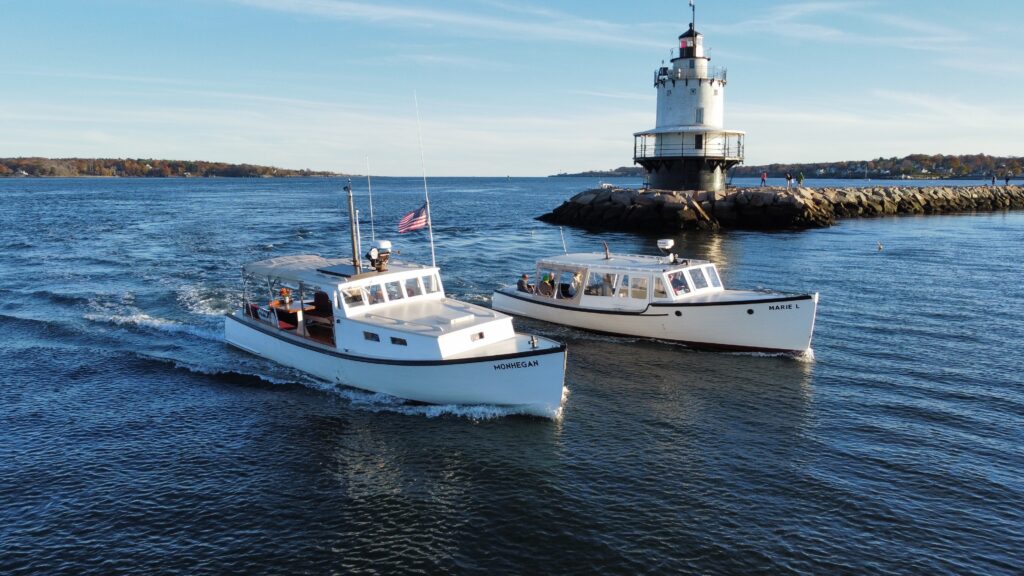 Boats cruising by lighthouse - Photo Courtesy of Casco Bay Custom Charters